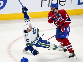 Vancouver Canucks' Bo Horvat (53) is tripped by Montreal Canadiens defenceman Jeff Petry during first period NHL hockey action in Montreal, Monday, Nov. 29, 2021.