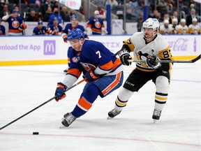 New York Islanders defenceman Grant Hutton (7) plays the puck against Pittsburgh Penguins centre Sidney Crosby (87) during the third period at UBS Arena.