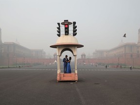 A couple poses during a pre-wedding photo shoot near India's Presidential Palace which is shrouded in smog, in New Delhi, India, November 5, 2021.