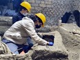 Archaeologists work inside a "slaves room" discovered at a Roman villa near the ancient Roman city of Pompeii, destroyed in 79 AD in volcanic eruption, Italy, 2021.