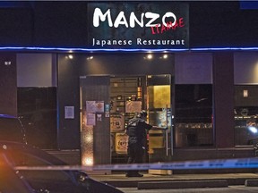 VANCOUVER, B.C.: SEPTEMBER 18, 2020 – A police officer enters Manzo Japanese Restaurant where two people were shot at in Richmond, B.C. on September, 18, 2020.