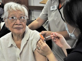 Dogwood Lodge resident Magdalena Bakar getting her COVID-19 Pfizer booster shot from registered nurse Serena Soo on Oct. 27, 2021.