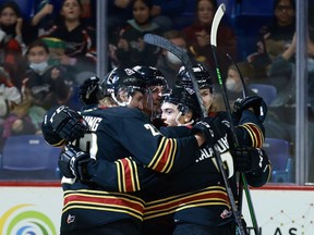 Rookie Ty Halaburda sneaks a peek in the direction of the photographer, while getting lots of love from his teammates, after scoring his first ever WHL goal against the Kelowna Rockets last Friday.