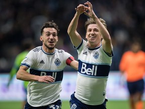 Vancouver Whitecaps' Ryan Gauld, right, and Russell Teibert celebrate Gauld's goal against the Seattle Sounders on Sunday at B.C. Place.