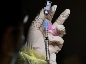 A registered pharmacist technician fills the Pfizer-BioNTech COVID-19 mRNA vaccine at a vaccine clinic during the COVID-19 pandemic in Toronto on Tuesday, December 15, 2020.