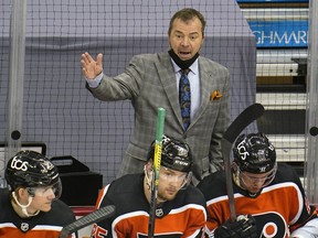 Former Philadelphia Flyers head coach Alain Vigneault, top, makes a point to the referee during an NHL game against the Pittsburgh Penguins in Pittsburgh, Thursday, April 15, 2021.