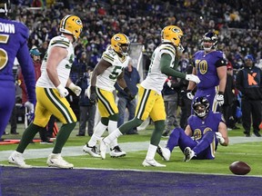 Members of the Green Bay Packers celebrate after a two-point conversion attempt to Baltimore Ravens tight end Mark Andrews (seated) failed in the second half of an NFL game Dec. 19, 2021, in Baltimore. Green Bay won 31-30.