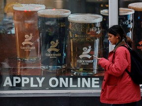 In this Nov. 9, 2017 file photo, a sign advertising available jobs at the Clocktower Brew Pub hangs in a window in Ottawa.