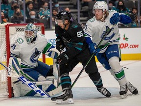 Sharks left wing Jayden Halbgewachs and Vancouver Canucks right wing Brock Boeser battle for position in front of goalie Thatcher Demko in the second period at SAP Center in San Jose.