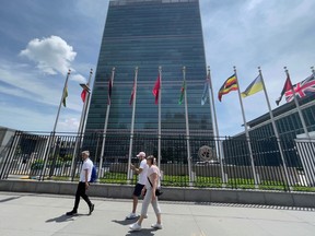 In this June 8, 2021 file photo, people walk past the United Nations headquarters building on the East Side of Manhattan in New York City.