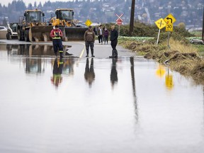 Nov. 30, 2021 - People watch the rising flood waters coming from the United States into Huntington Village in Abbotsford, B.C., Monday, November 29, 2021.