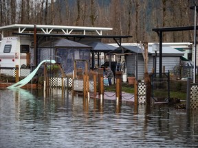 Debbie Gorse cleans up her property after floodwaters began to recede at Everglades Resort on Hatzic Lake near Mission, B.C., on Sunday, December 5, 2021.