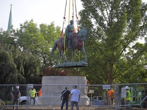 A statue of Confederate general Robert E. Lee is lifted off its pedestal in Market Street Park in Charlottesville on July 10. MUST CREDIT: Washington Post photo by John McDonnell