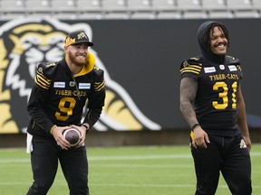 Tiger-Cats quarterback Dane Evans and running back Sean Thomas Erlington (31) laugh during practice on Saturday.