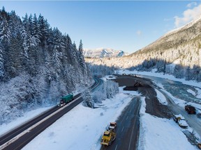 A transport truck hauling pipe travels on the Coquihalla Highway after it was reopened to commercial traffic as heavy equipment is used to rebuild the southbound lanes that were washed away by flooding last month at Othello, northeast of Hope, on Monday, Dec. 20, 2021.