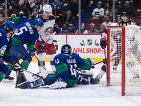 Canucks defenceman Tucker Poolman (second from left) during a first-period scramble at Rogers Arena on Tuesday night that resulted in a Columbus Blue Jackets goal. Poolman, who had 5:37 of ice time before being pulled out of the game because of a late-arriving positive COVID test result, may have put his teammates and opponents at risk.