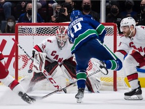 Vancouver Canucks' Elias Pettersson (40), scores against Carolina Hurricanes goalie Antti Raanta (32), as Ian Cole (28) defends during the second period on Sunday night.