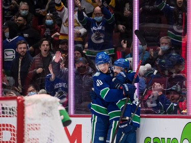 Vancouver Canucks' Elias Pettersson, left, of Sweden, and Conor Garland celebrate Garland's goal against the Los Angeles Kings during second period NHL hockey action in Vancouver, B.C., Monday, Dec. 6, 2021.
