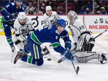 Vancouver Canucks' Brock Boeser (6) is checked by Los Angeles Kings' Drew Doughty (8) as he reaches for the puck in front of goalie Calvin Petersen (40) during second period NHL hockey action in Vancouver, B.C., Monday, Dec. 6, 2021.