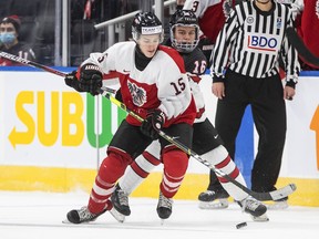 Canada's Connor Bedard, right, and Austria's Fin van Ee battle for the puck during Tuesday night's world junior hockey championship game in Edmonton. Bedard had four goals to lead Canada to an 11-2 win. The tournament has now been cancelled due to positive COVID tests for several teams.