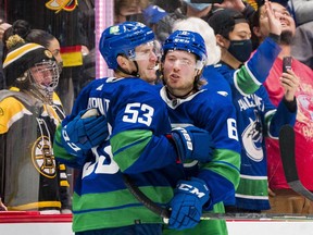 Brock Boeser (right) giving a hug to captain Bo Horvat after the Canucks’ Dec. 8 shootout win over Boston, has been firing away — and scoring more often — in the six games under new coach Bruce Boudreau.