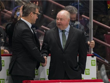 New Vancouver Canucks assistant coach Scott Walker congratulates new head coach Bruce Boudreau on his first victory over the Los Angeles Kings  in the third period at Rogers Arena. Vancouver won 4-0.