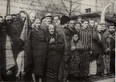 Holocaust survivors stand behind a barbed wire fence after the liberation of Nazi German death camp Auschwitz-Birkenau in 1945 in Nazi-occupied Poland, in this handout picture obtained by Reuters on Jan. 19, 2020. (Courtesy of Yad Vashem Archives)