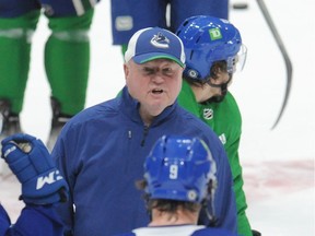 New Canucks head coach Bruce Boudreau gets his message across to veteran forward J.T. Miller during team practice on Tuesday at Rogers Arena.