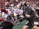Then-Vancouver Warriors defender Matt Beers (right) tries to check Calgary Roughnecks Dane Dobbie during a December 2018 National Lacrosse League game at Rogers Arena.