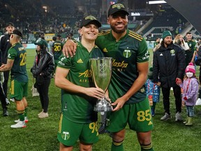 Portland Timbers midfielder Blake Bodily (left) and defender Zac McGraw pose with the MLS Western Conference trophy after defeating Real Salt Lake 2-0 on Dec. 4, 2021 at Providence Park in Portland.