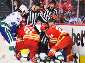 Brett Ritchie of the Calgary Flames fights Tyler Myers  of the Vancouver Canucks after Myers checked Ritchie's teammate Trevor Lewis during an NHL game at Scotiabank Saddledome on January 29, 2022 in Calgary.