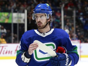 VANCOUVER, BC - NOVEMBER 21: Conor Garland #8 of the Vancouver Canucks looks on from the bench during their NHL game against the Chicago Blackhawks at Rogers Arena November 21, 2021 in Vancouver, British Columbia, Canada.