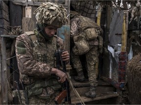 Ukrainian soldiers stand in a trench near the front line on January 17, 2022 in the village of New York, formerly known as Novhorodske, Ukraine.