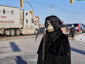 Protesters of COVID-19 restrictions, and supporters of Canadian truck drivers protesting the COVID-19 vaccine mandate cheer on a convoy of trucks on their way to Ottawa, on the Trans-Canada Highway west of Winnipeg, Manitoba, Tuesday January 25, 2022.