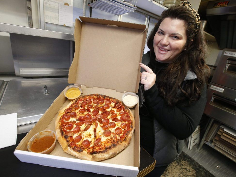 Jade Chaput of Jr's Handmade Sourdough Pizza food truck in Bowmanville shows off the piping hot personal sized Cup and Char pizza along with three hand-made delicious dipping sauces. The pizza trailer has been in business for the past eight years and is right beside Hanc's Fries going since 1971 in Bowmanville.