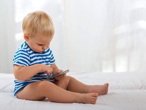 Casual baby watching a mobile phone