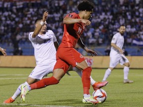 Honduras' Diego Rodriguez, left, pressures Canada's Tajon Buchanan during a qualifying soccer match for the FIFA World Cup Qatar 2022 in San Pedro Sula, Honduras, Thursday, Jan. 27, 2022.