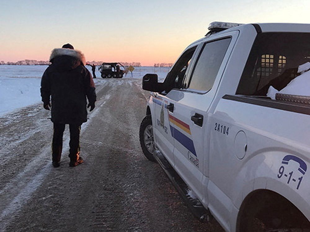RCMP officers search the area where a family of four froze to death after crossing the border from the U.S. near Emerson, Manitoba.