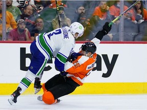 Philadelphia Flyers' James van Riemsdyk, right, and Vancouver Canucks' Jack Rathbone collide during the second period of an NHL hockey game, Friday, Oct. 15, 2021, in Philadelphia.