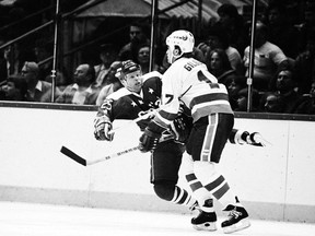 Washington Capitals centre and long-time iron man Doug Jarvis (left) takes a heavy check from New York Islander Greg Gilbert during a December 1983 National Hockey League game in Uniondale, N.Y.