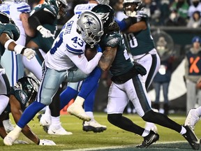 Dallas Cowboys running back Ito Smith (43) scores a touchdown as Philadelphia Eagles defensive back Andre Chachere (21) defends during the fourth quarter at Lincoln Financial Field Jan. 8.