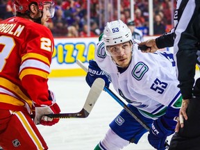 Canucks captain Bo Horvat, sidelined by COVID protocols, is expected to renew his rivalry with Elias Lindholm (left) and the Calgary Flames when he returns to the lineup Saturday and the teams face off in the Stampede City.