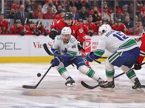 Le centre des Canucks de Vancouver Tyler Motte (64) patine loin de l'ailier droit des Blackhawks de Chicago Patrick Kane (88) au cours de la première période au United Center.