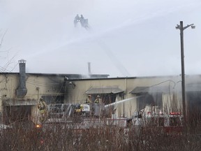 Ottawa firefighters work to extinguish a fire on Merivale Road in Ottawa Thursday afternoon.