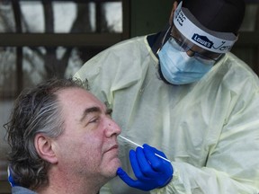 Nurse David Sidhu performs a COVID-19 rapid test on Three Links CEO David Hurford at the agency's care home in East Vancouver.