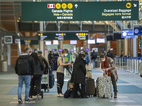 People move their luggage at Vancouver International Airport (YVR) on Dec. 16, 2021.