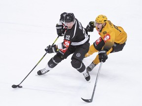 Lugano's Santeri Alatalo, left, fights for the puck with Skelleftea's Linus Karlsson during the Champions League ice hockey match between HC Lugano and Skelleftea AIK at the ice stadium Corner Arena in Lugano, Switzerland, Friday, Aug. 27, 2021.