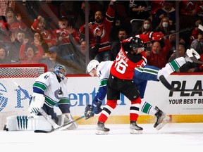 Jack Hughes #86 of the New Jersey Devils crashes into Tyler Myers #57 of the Vancouver Canucks as he scores his first period goal at the Prudential Center on February 28, 2022 in Newark, New Jersey.