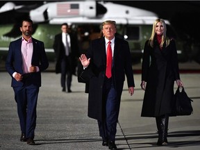 In this file photo taken on January 4, 2021 US President Donald Trump (C), daughter Senior Advisor Ivanka Trump and son Donald Trump Jr. (L) make their way to board Air Force One.