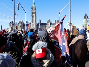 A person carries a Confederate battle flag in front of Parliament Hill as truckers and supporters take part in a convoy to protest COVID-19 vaccine mandates in Ottawa on Jan. 29.